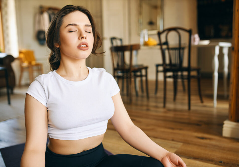 beautiful-young-caucasian-woman-with-muscular-curvy-body-sitting-lotus-posture-home-keeping-eyes-closed-meditating-during-yoga-practive-doing-body-scanning-concentrating-breathing